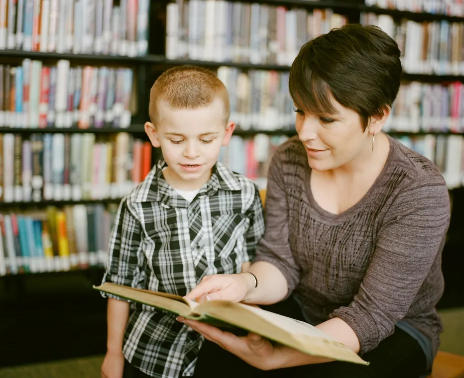 Adult and child reading in a library